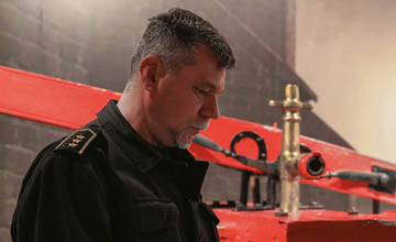 Asp. sztab. w st. spocz. Arkadiusz Ogrodowski oprowadza po salach i opowiada o nich za pomocą multimediów sterowanych z tabletu, fot. Artur Kowalczyk / red. PP