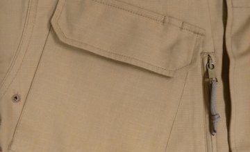 Fot. 2. Ułożenie skośnej kieszeni piersiowej bluzy służbowej. Widoczny jest też pionowy zamek kieszeni umieszczonej pod nią. Uwagę zwraca sznurek pleciony Ø 3 mm. Ciekawostką są szczegóły konstrukcji patki kieszeni zewnętrznej. Widzimy tu zarysy ukrytych wewnątrz patki nap miedzianych oraz wpust długopisu