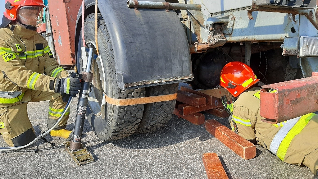 Podnoszenie koła za felgę wklęsłą z jednoczesną stabilizacją wspomagającą pod osią (w miarę możliwości jak najbliżej podnoszonego koła) / fot. Rafał Podlasiński