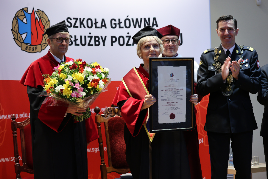 Melania Pofit-Szczepańska podczas uroczystości wręczenia honoris causa z rektorem komendantem nadbryg. dr inż. Mariuszem Feltynowskim, profesorem uczelni (z prawej) oraz recenzentami osiągnięć i zasług kandydatki - prof. dr hab. Mirosławem Minkiną oraz prof. dr hab. Bronisławem Sitkiem / fot. Grzegorz Trzeciak / KG PSP