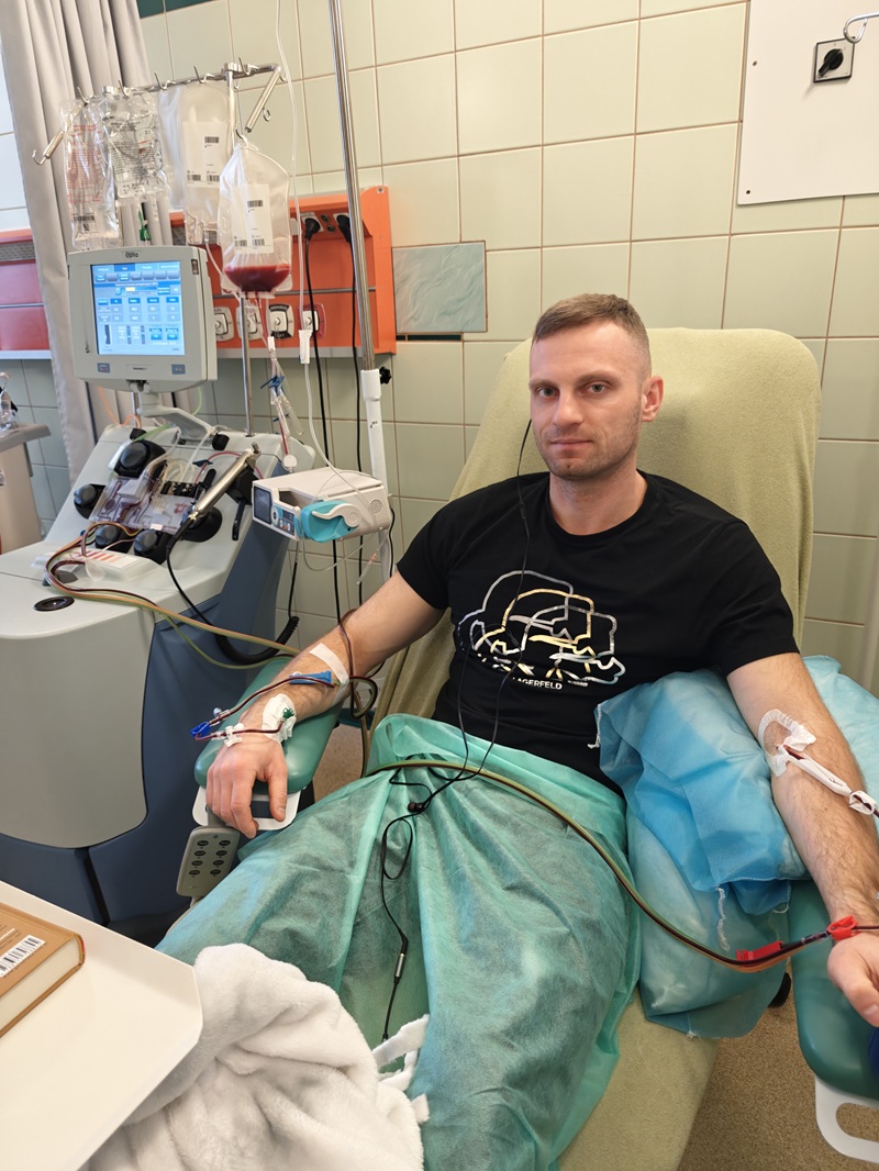 Mężczyzna w szpitalnej sali. Mężczyzna podłączony jest do szpitalnej aparatury. Trwa procedura pobierania komórek macierzystych.