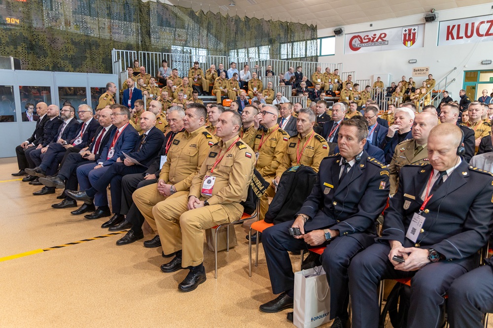 Zdjęcie pibliczności. Na krzesłach siedzą zgromadzeni goście. 
