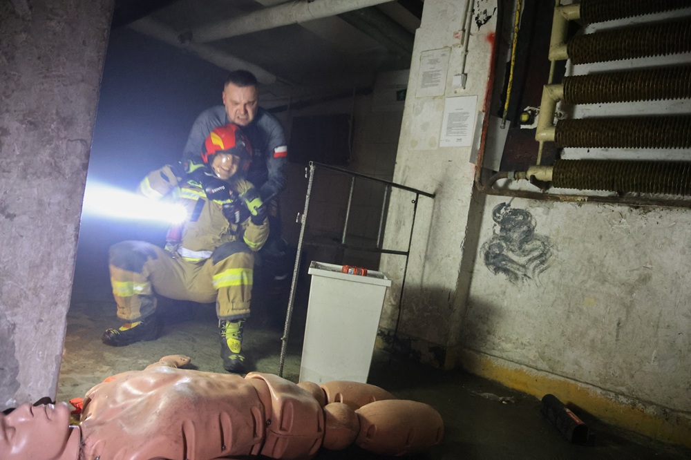 Zdjęcie przedstawiające symulowany atak na strażaka. Strażk przejął niebezpieczny przedmiot od napastnika.