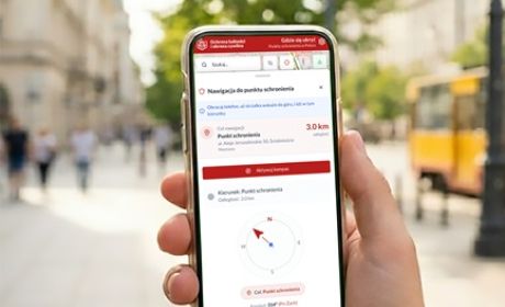 Osoba trzyma w ręku smartphone z otwartą aplikacją. Aplikacja wskazujwe trasę.